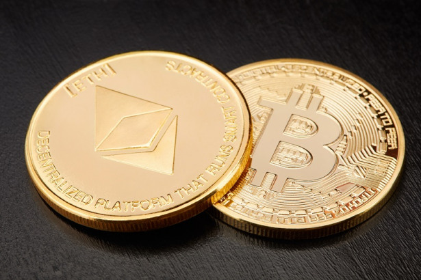Ethereum and Bitcoin, two golden cryptocurrency coins on black background