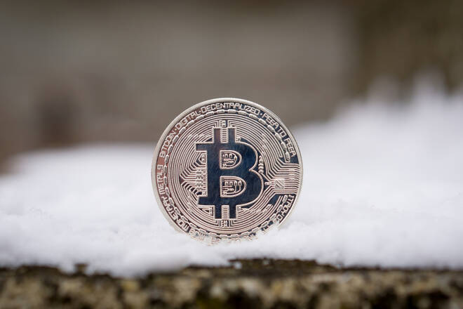 A silver Bitcoin placed in snow on concrete. Isolated scene of cryptocurrency in snow