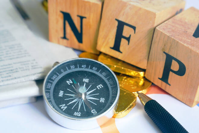 Text "NFP" on wood cube with gold bar and compass and newspaper on the table, economic data concept