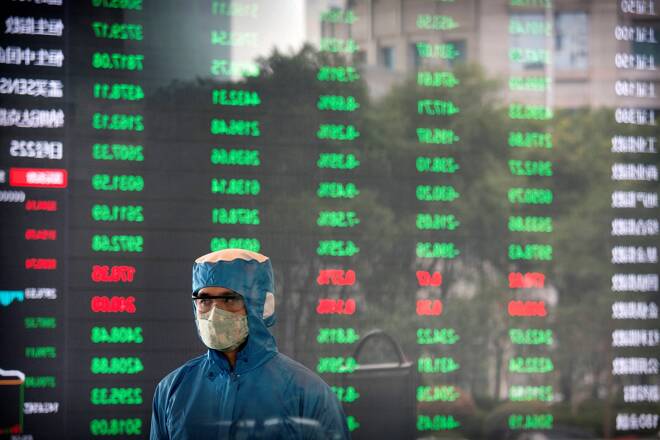 A worker wearing a protective suit stands in front of an electronic display board in the lobby of the Shanghai Stock Exchange building in Shanghai, Monday, Feb. 3, 2020. The Shanghai Composite index tumbled 8.7% Monday then rebounded slightly as Chinese regulators moved to stabilize markets reopening from a prolonged national holiday despite a rising death toll from a new virus that has spread to more than 20 countries. (AP Photo)
