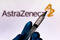 October 4, 2020, Brazil. In this photo illustration the medical syringe is seen with AstraZeneca company logo displayed on a screen in the background.