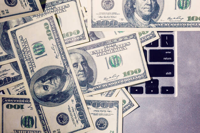 Closeup view of one hundred dollar banknotes lying on the laptop