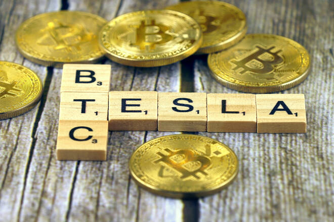 TESLA and BTC (Bitcoin) made of small wooden letters, and physical version of Bitcoin.