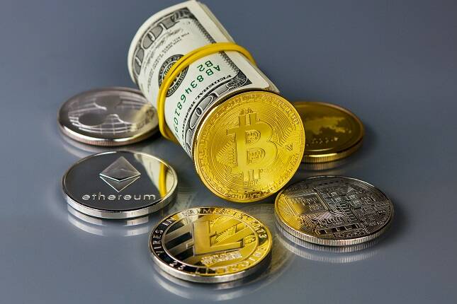 Kiev, Ukraine, March, 13, 2018: Coins of different crypto-currencies with dollars