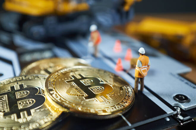 bitcoin mining concept; miniature Excavator and Bitcoin coins