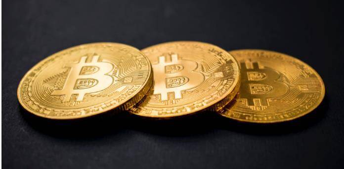 Three Bitcoin coins lying on a table