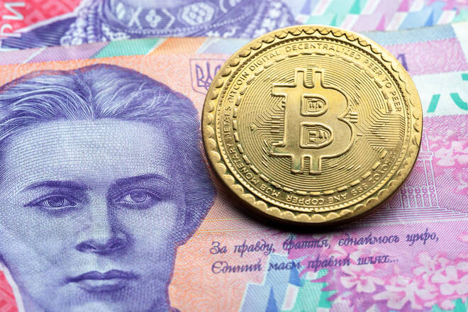 bitcoin symbol at ukrainian paper currency background. cryptocurrency technologies concept. virtual money with real life.