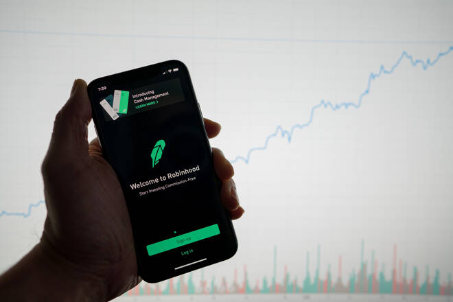 Robinhood app on with white financial stock chart with price rising upward positive in background