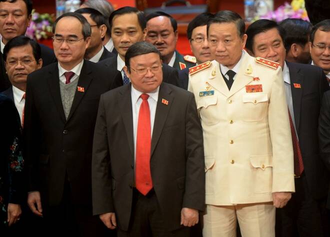 Newly elected Politburo member To Lam, in white uniform, poses in Hanoi