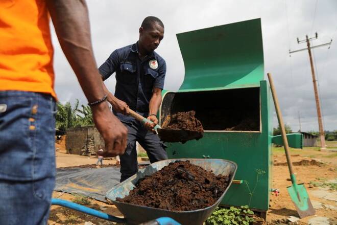 Agents remove organic fertilizer from a Kubeko machine, in Nandibo