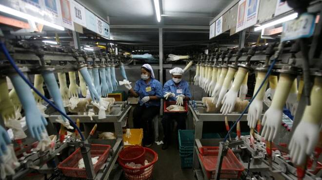 Workers collect rubber gloves at Top Glove's factory in Klang