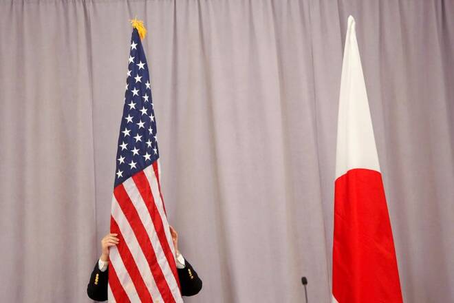 A worker adjusts the U.S. flag before Japanese Prime Minister Shinzo Abe addresses media following a meeting with President-elect Donald Trump in Manhattan, New York, U.S.