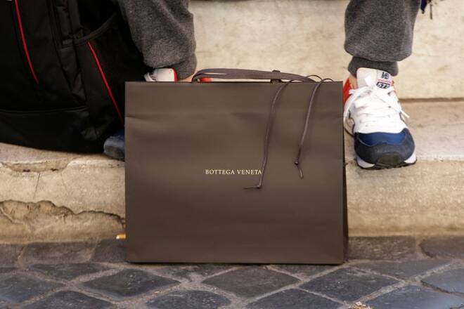 A man sits next a Bottega Veneta bag in downtown Rome