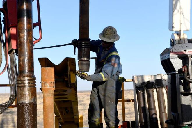 An oil worker removes a thread cap from a piece of drill pipe on a drilling lease owned by Elevation Resources near Midland