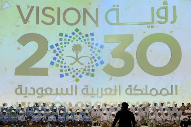 Large banner shows Saudi Vision for 2030 as a soldier stands guard before the arrival of Saudi King Salman at the inauguration of several energy projects in Ras Al Khair