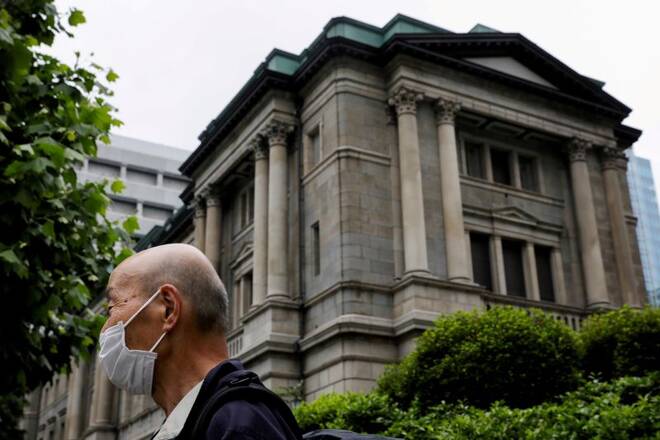 A man stands in front of the headquarters of Bank of Japan