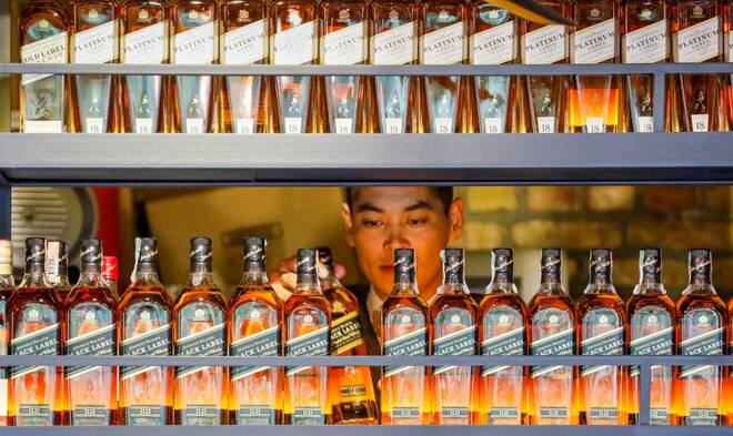 A bartender takes a bottle of Johnnie Walker whisky at Barmaglot bar in Almaty