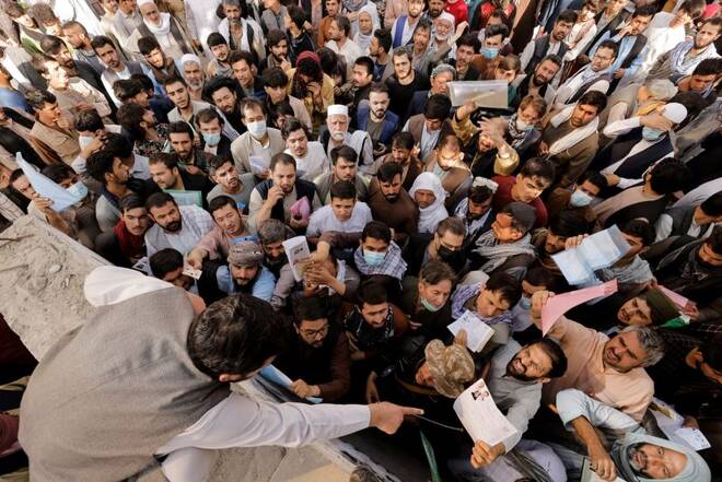 Afghans gather outside the passport office after Taliban officials announced they will start issuing passports to its citizens again