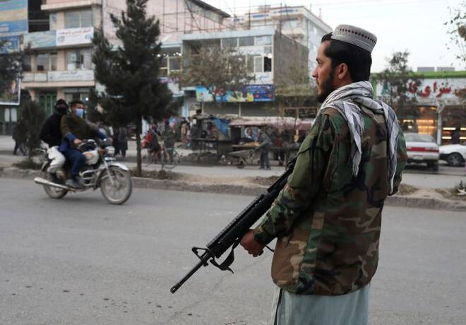Taliban fighter stands guard at the site of a blast in Kabul