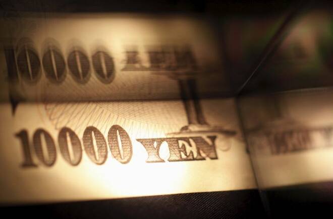 Light is cast on a Japanese 10,000 yen note as it's reflected in a plastic board in Tokyo, in this picture illustration
