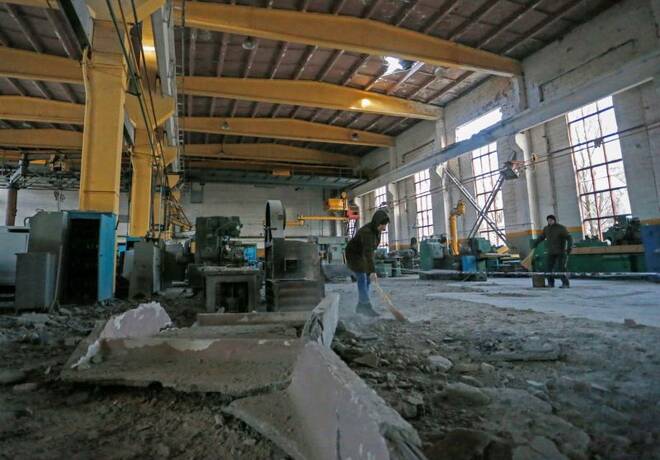 People remove debris inside a machine-building plant in the rebel-controlled town of Yasynuvata