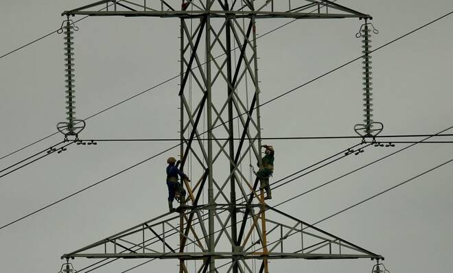 Workers paint an electricity pylon near Lymm, northern England
