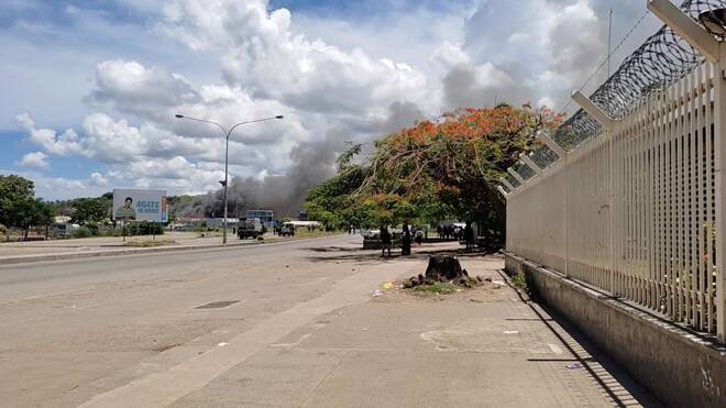 Smoke is seen after buildings were set on fire in Chinatown during protest in Honiara
