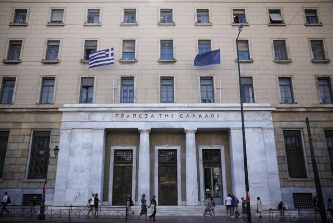 People make their way outside the Bank of Greece headquarters in Athens