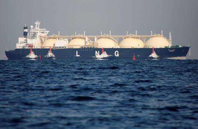A LNG tanker is tugged towards a thermal power station in Futtsu