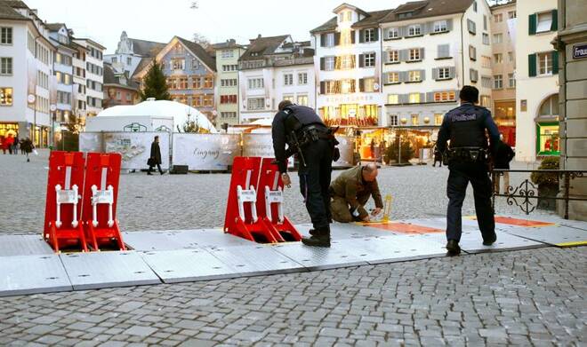 Swiss police officers prepare mobile barriers blocking a street to protect a Christmas market, in Zurich