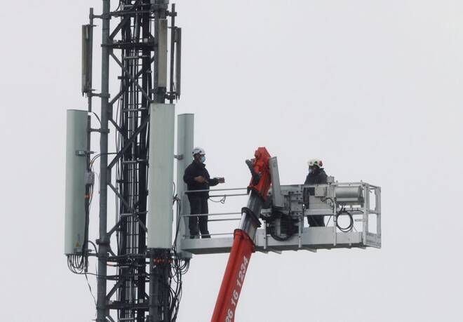 Technicians work at the top of transmitting antennas are seen on a mobile-phone network relay mast in Lambres-lez-Douai