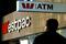 A pedestrian passes below signs for Westpac Bank during the company's strategy update meeting in cen..