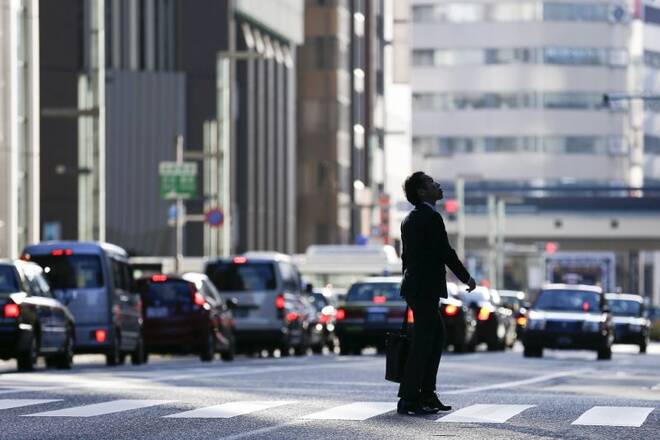 A businessman looks up as he crosses a street in a district in central Tokyo