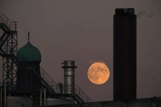 A strawberry moon is seen over chimneys at the Guinness factory during sunset in Dublin