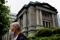 A man wearing a protective mask stands in front of the headquarters of the Bank of Japan in Tokyo
