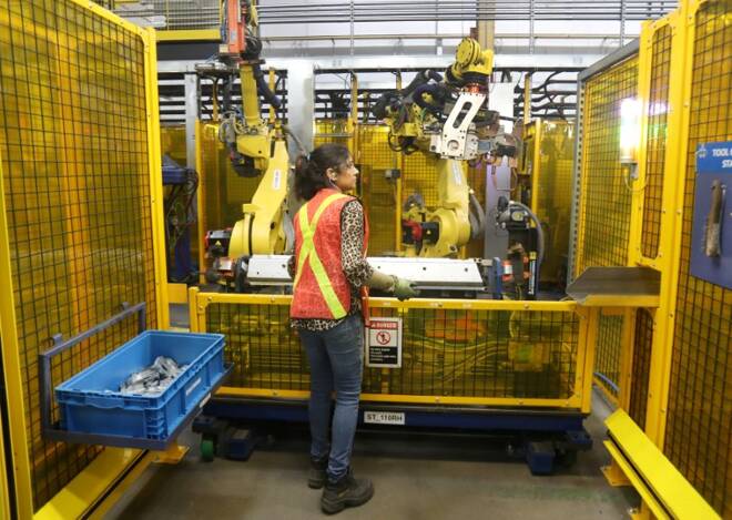 Worker loads part for welding in robot bay at Alfield Industries, a subsidiary of Martinrea, one of three global auto parts makers in Canada.