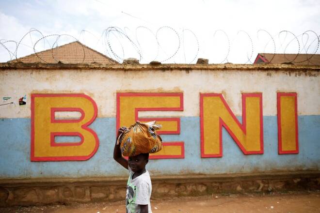 A Congolese boy walks past a wall near the Alima Ebola treatment centre in Beni