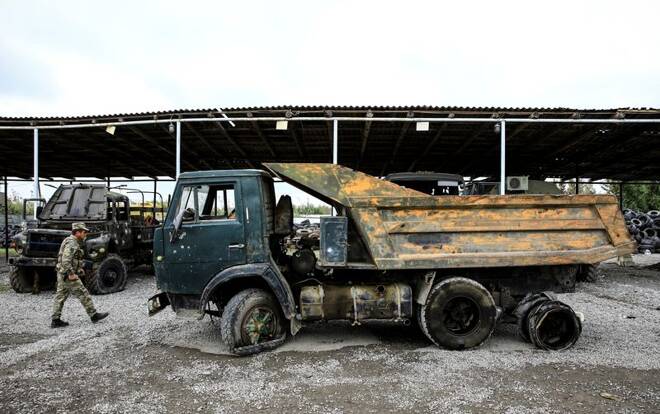 An Azeri soldier walks past an Armenian military truck which was seized by the Azerbaijan army during the fighting over the breakaway region of Nagorno-Karabakh, near the city of Barda
