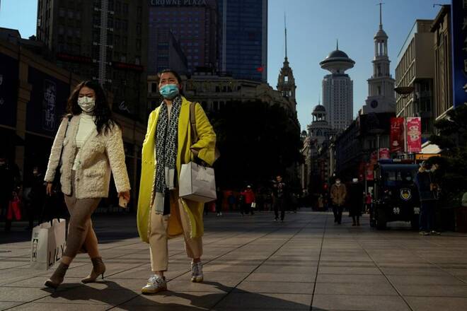 People wearing protective masks walk on a street, following the new cases of the coronavirus disease (COVID-19), in Shanghai