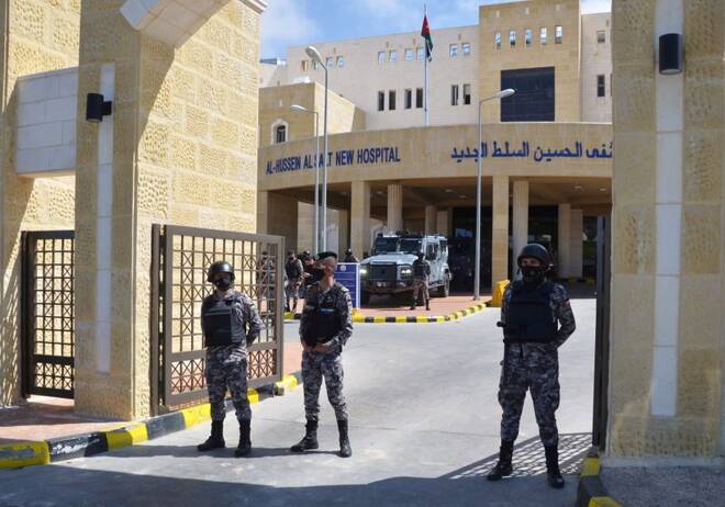 Gendarmerie officers stand guard at the gate of the new Salt government hospital in the city of Salt