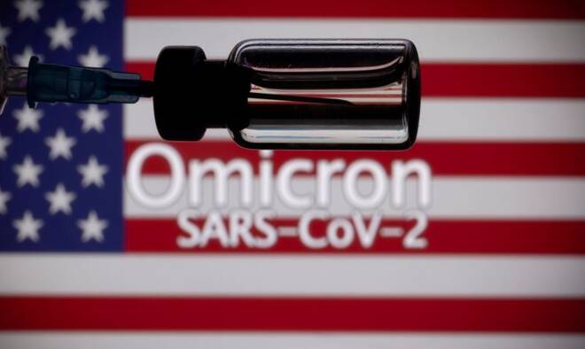 A vial and a syringe are seen in front of a displayed United States' flag and words "Omicron SARS-CoV-2" in this illustration taken