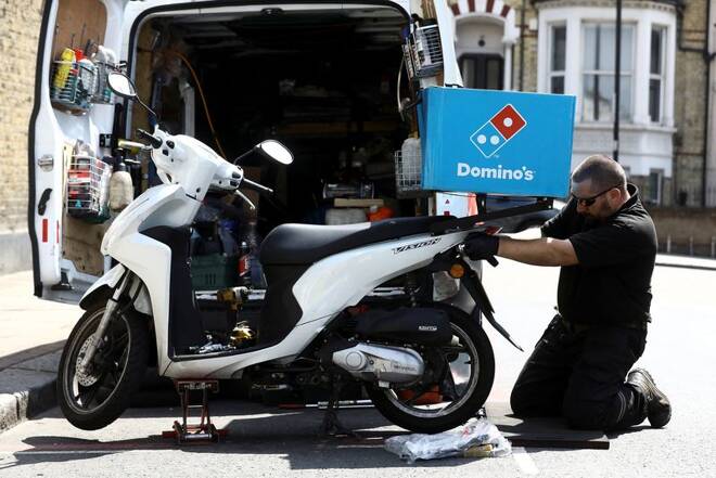 A call out mechanic fixes a Dominos delivery scooter in the Clapham district of London