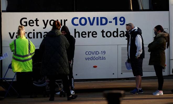 People wait to get COVID-19 booster vaccine at mobile vaccination centre in Bolton