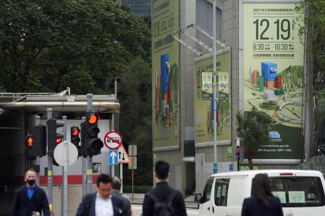 Pedestrians walk past advertisements for the upcoming Legislative Council election in Hong Kong