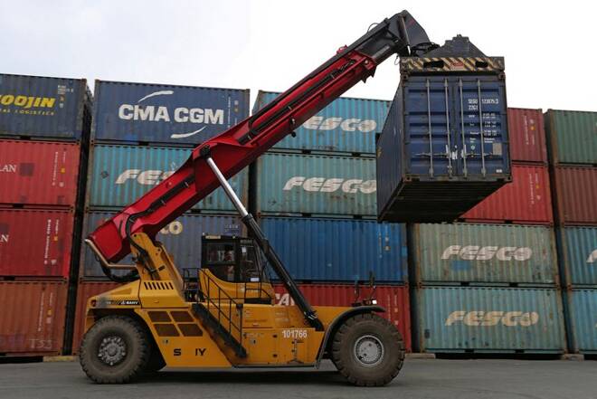 A vehicle moves a shipping container at a commercial port in Vladivostok