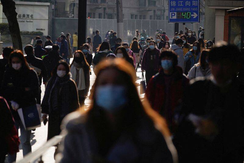 People wearing protective masks walk on a street, following new cases of the coronavirus disease (COVID-19), in Shanghai