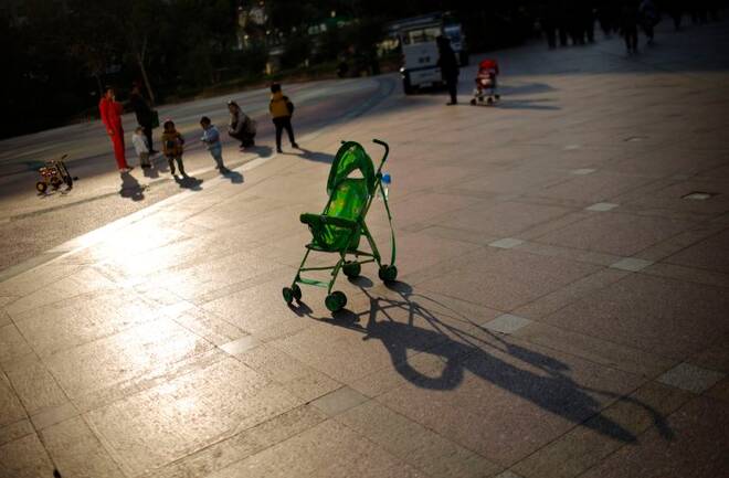 A baby stroller is seen as mothers play with their children at a public area in downtown Shanghai