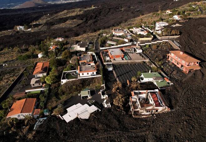 Aerial view of a group of houses surrounded by the lava of the Cumbre Vieja volcano in an exclusion zone in Las Manchas