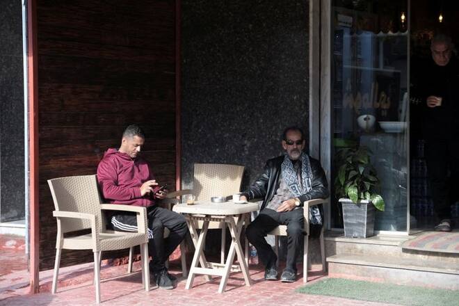 People sit in a cafe after postponement of elections by the High National Elections Commission, in Benghazi