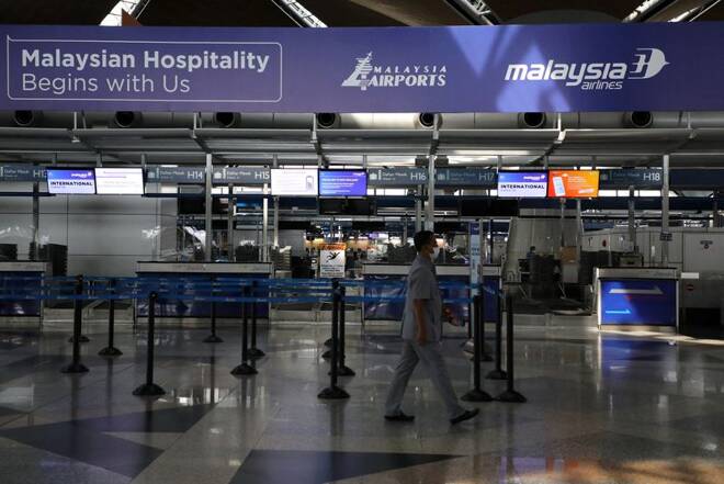 A man wearing a protective mask walks past Malaysia Airlines check in counter at Kuala Lumpur International Airport, amid the coronavirus disease (COVID-19) outbreak in Sepang
